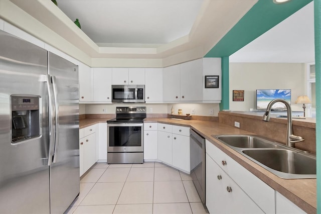 kitchen with appliances with stainless steel finishes, white cabinetry, and sink