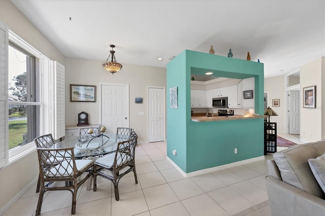 dining area featuring light tile patterned flooring and sink