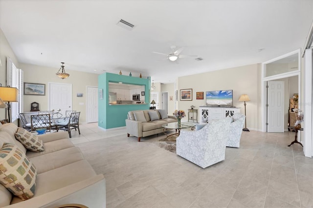 tiled living room with ceiling fan