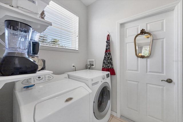 clothes washing area featuring washing machine and clothes dryer and light tile patterned floors