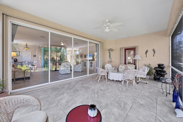 sunroom / solarium featuring ceiling fan