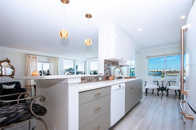 kitchen featuring dishwasher, pendant lighting, decorative backsplash, a breakfast bar, and light wood-type flooring