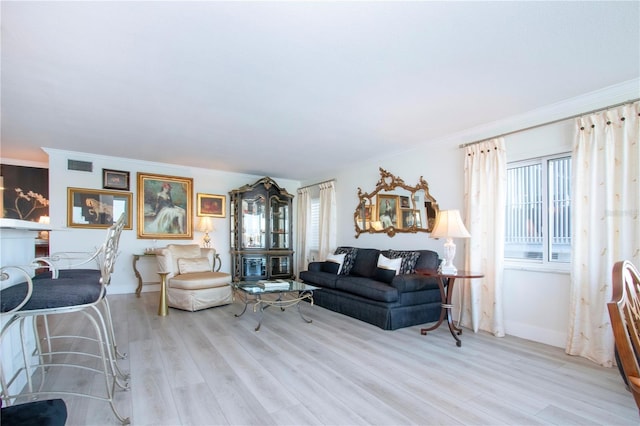 living room featuring light hardwood / wood-style floors and ornamental molding