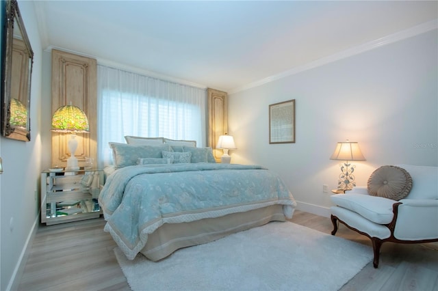 bedroom featuring crown molding and light hardwood / wood-style flooring