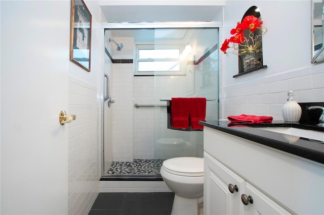 bathroom featuring vanity, tile patterned floors, toilet, tile walls, and walk in shower