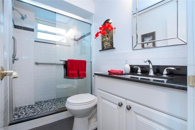 bathroom featuring decorative backsplash, vanity, toilet, and a shower with shower door