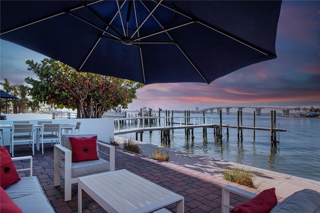 view of dock with a water view and a patio area