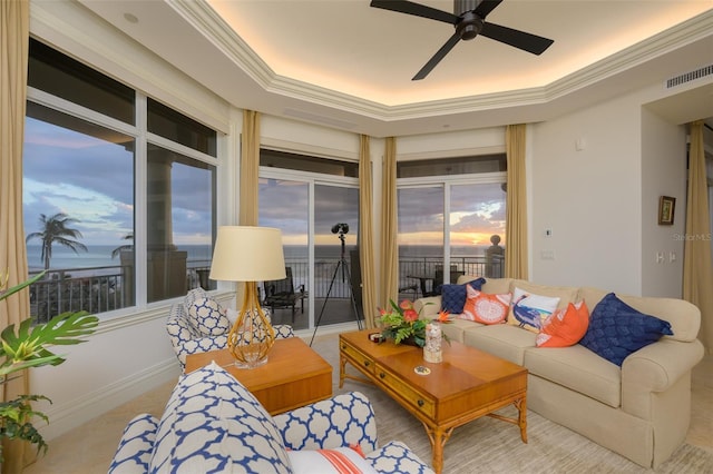 living room featuring ceiling fan, a raised ceiling, and crown molding