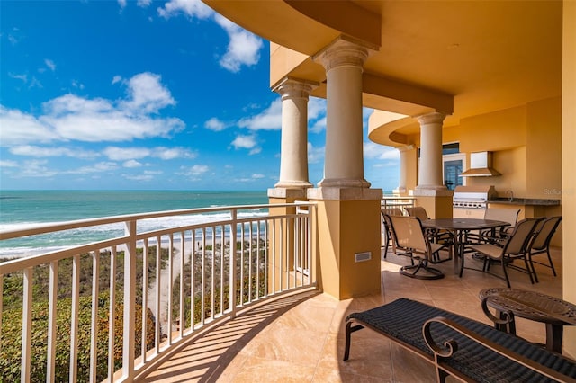 balcony featuring a grill, a water view, a beach view, and sink