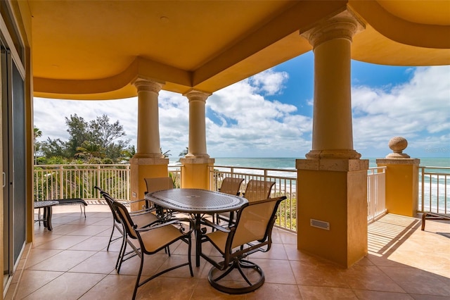 view of patio featuring a water view, a balcony, and a view of the beach