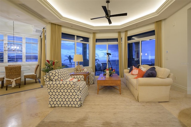 living room featuring ceiling fan with notable chandelier, crown molding, and a tray ceiling