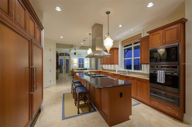 kitchen featuring a kitchen bar, kitchen peninsula, ceiling fan, pendant lighting, and dark stone countertops