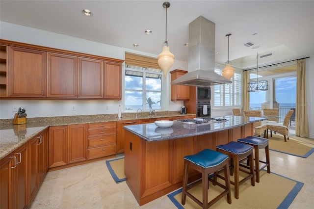 kitchen with light stone countertops, oven, pendant lighting, a kitchen bar, and island range hood