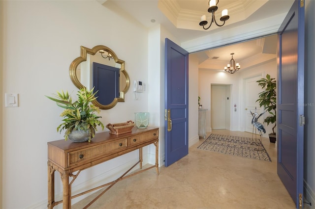 interior space featuring a tray ceiling, a chandelier, and ornamental molding