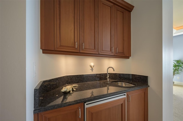 kitchen featuring carpet flooring, dark stone countertops, and sink