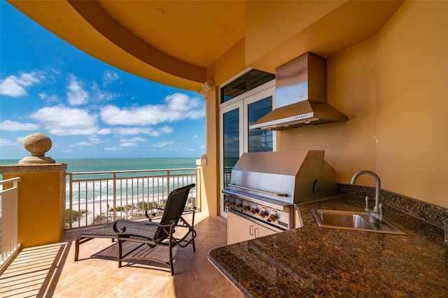 exterior space with a view of the beach, a water view, grilling area, and sink