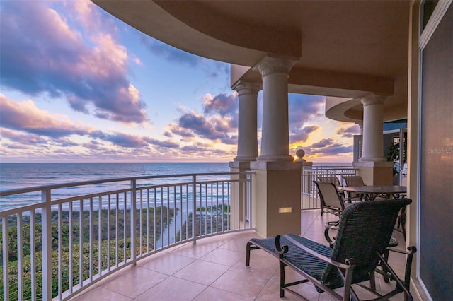 balcony at dusk with a view of the beach and a water view