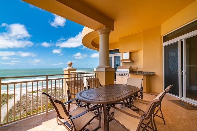 balcony with a beach view, a water view, and grilling area