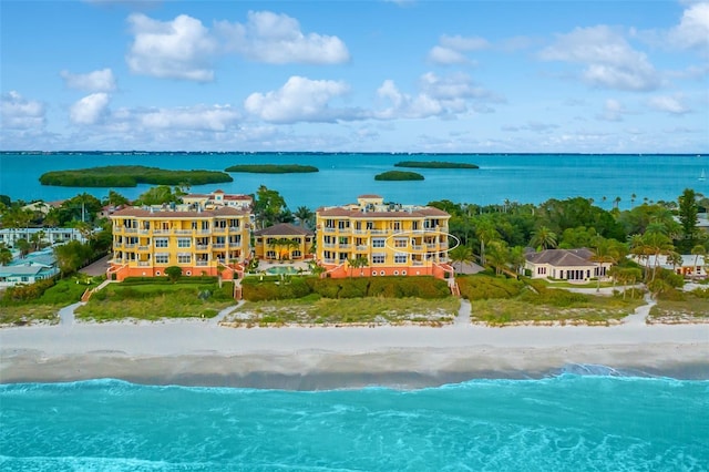 birds eye view of property with a water view and a beach view