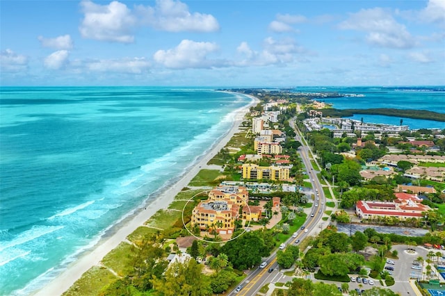 birds eye view of property with a water view and a beach view