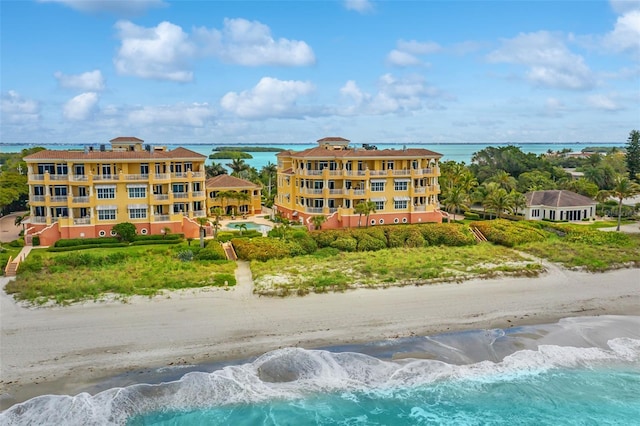 view of property featuring a water view and a beach view