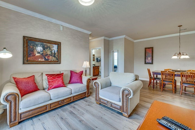 living room with crown molding, a notable chandelier, and light wood-type flooring