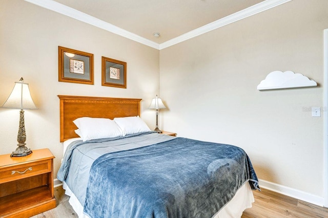 bedroom with light hardwood / wood-style floors and ornamental molding