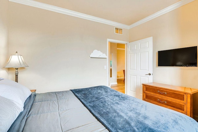 bedroom with hardwood / wood-style floors and ornamental molding