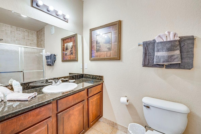 bathroom featuring tile patterned floors, vanity, toilet, and a shower with door