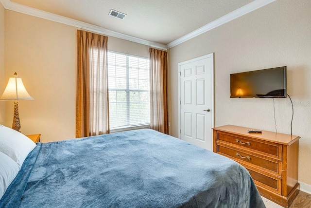 bedroom with crown molding and wood-type flooring