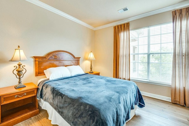 bedroom with light hardwood / wood-style floors and ornamental molding