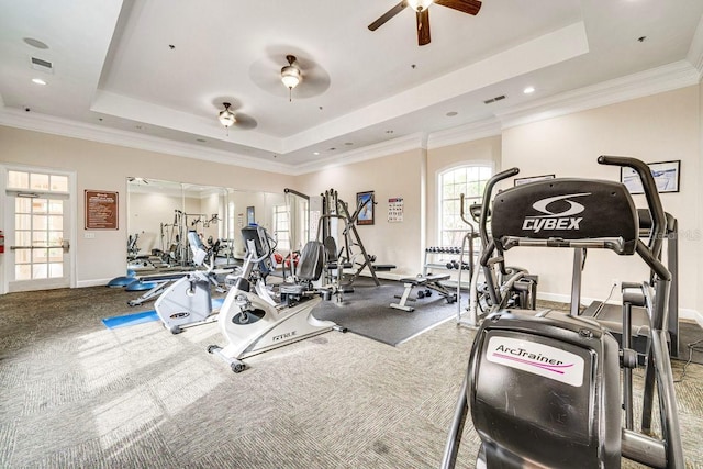 gym featuring carpet floors, a tray ceiling, ceiling fan, and crown molding