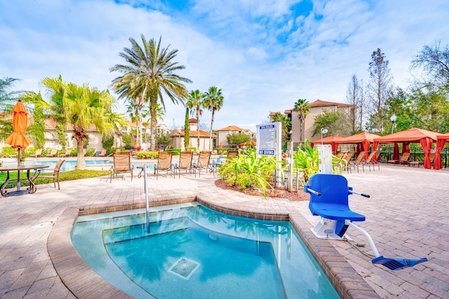 view of pool featuring a gazebo, a patio area, and a hot tub