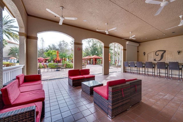 view of patio / terrace with a bar, an outdoor hangout area, and ceiling fan