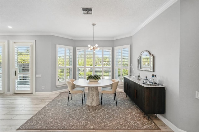 dining room featuring a notable chandelier, light hardwood / wood-style floors, ornamental molding, and a textured ceiling