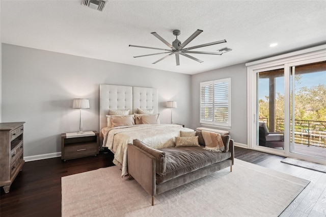 bedroom featuring ceiling fan, dark hardwood / wood-style flooring, access to exterior, and a textured ceiling