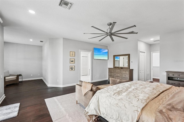 bedroom featuring a textured ceiling, ceiling fan, and dark wood-type flooring