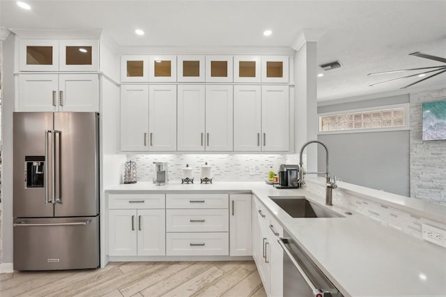 kitchen with stainless steel appliances, white cabinetry, tasteful backsplash, and sink