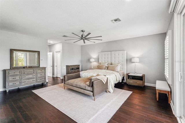 bedroom featuring a textured ceiling, dark hardwood / wood-style floors, and ceiling fan