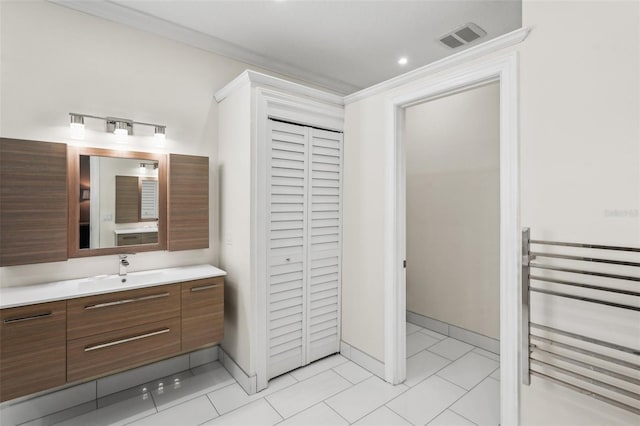 bathroom with visible vents, ornamental molding, tile patterned flooring, vanity, and a closet