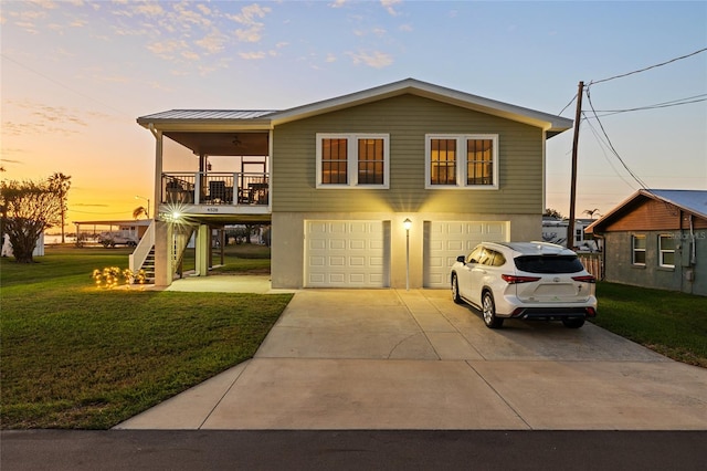 view of front of home with ceiling fan, a yard, covered porch, and a garage