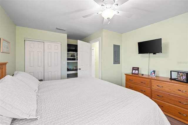 bedroom with ceiling fan, electric panel, and a closet