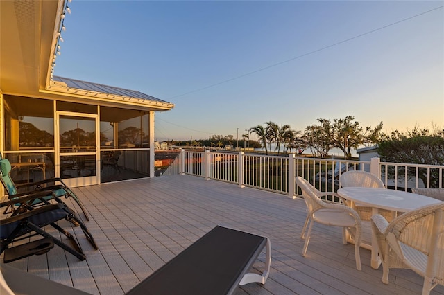 deck at dusk with a sunroom