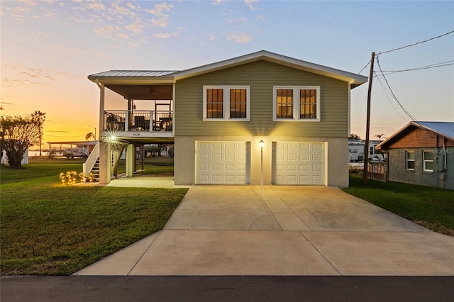 view of front of house featuring a porch, a yard, a garage, and ceiling fan