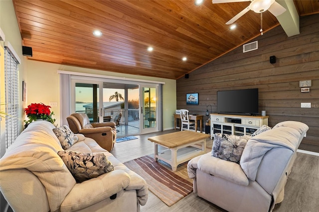 living room with wood ceiling, ceiling fan, wood-type flooring, high vaulted ceiling, and wood walls