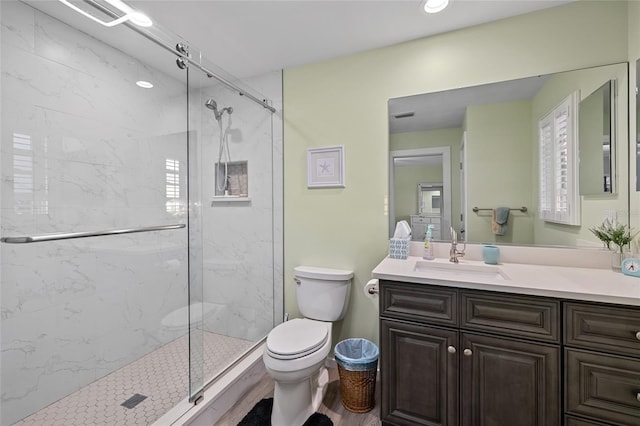 bathroom with vanity, toilet, and a shower with shower door