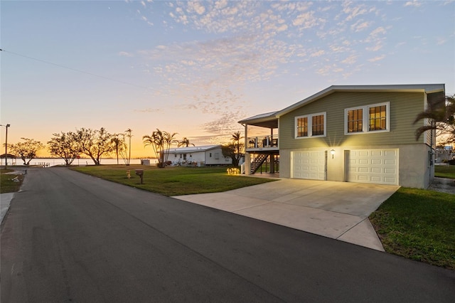 view of front of property featuring a lawn, a garage, and a wooden deck