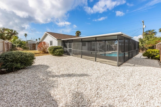 back of property with a fenced in pool, a patio area, a sunroom, and a lanai