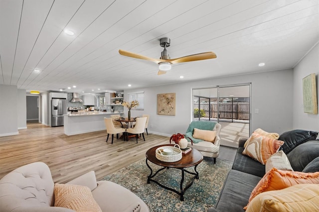 living room with ceiling fan, wood ceiling, and light wood-type flooring