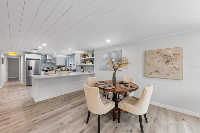 dining space with light hardwood / wood-style flooring and wood ceiling